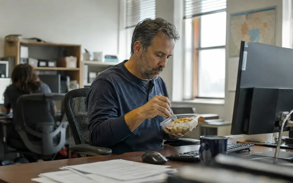 An employee eating lunch at his desk on an ordinary working day